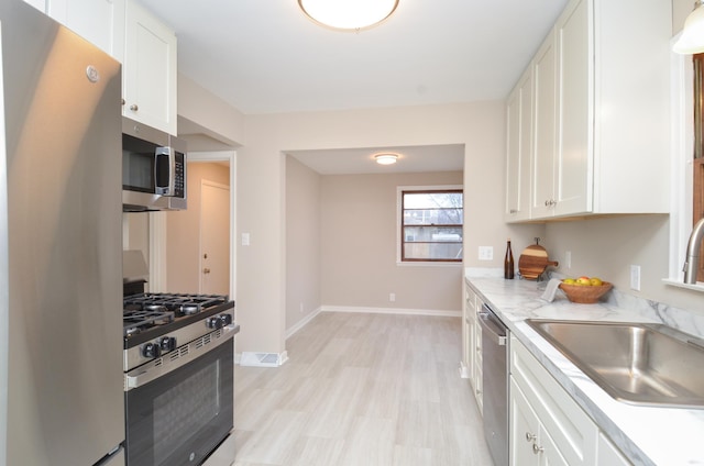 kitchen featuring white cabinetry, sink, and appliances with stainless steel finishes