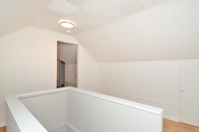 hallway with light hardwood / wood-style floors and lofted ceiling