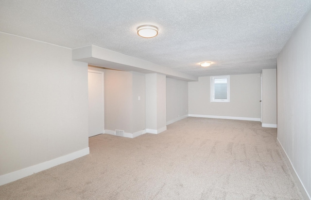 basement with a textured ceiling and light carpet