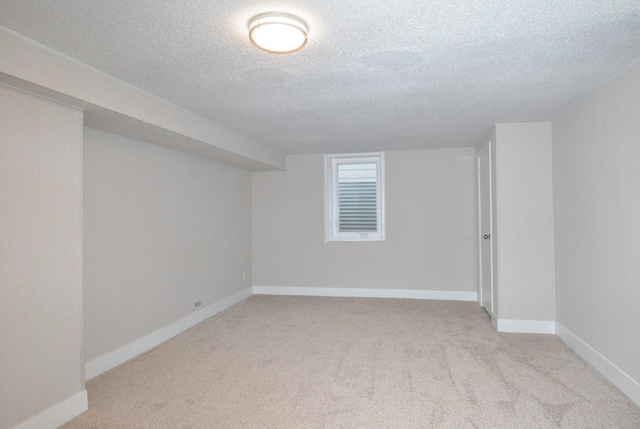 basement featuring light carpet and a textured ceiling