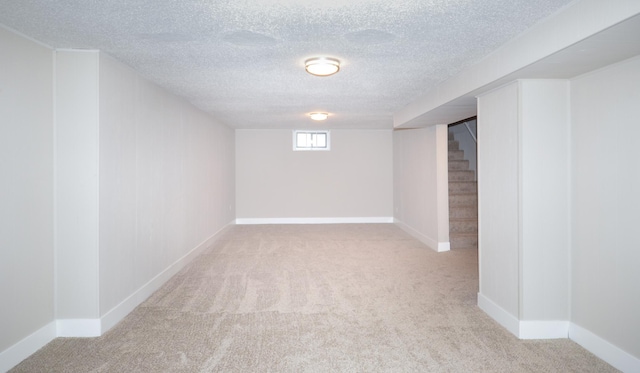 basement with light colored carpet and a textured ceiling