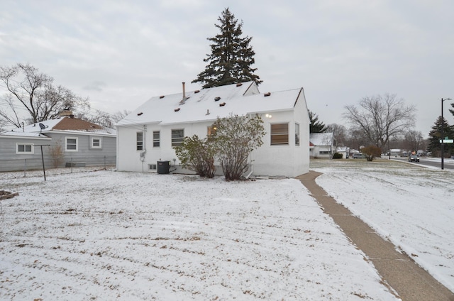 snow covered rear of property featuring central air condition unit