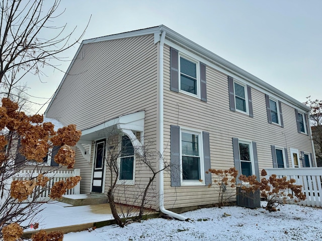 snow covered property featuring cooling unit