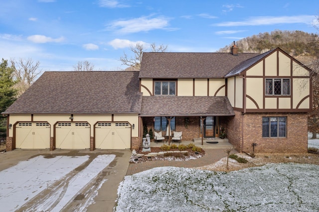 tudor-style house featuring a porch and a garage