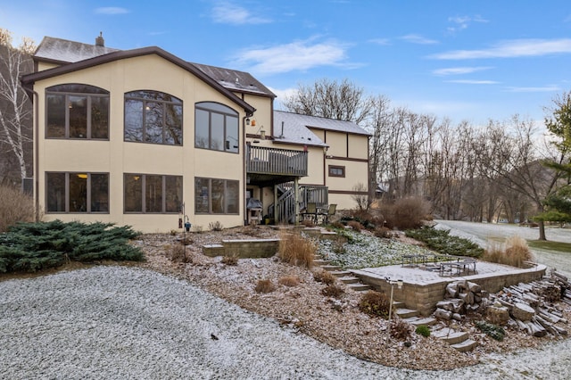 snow covered house featuring a deck