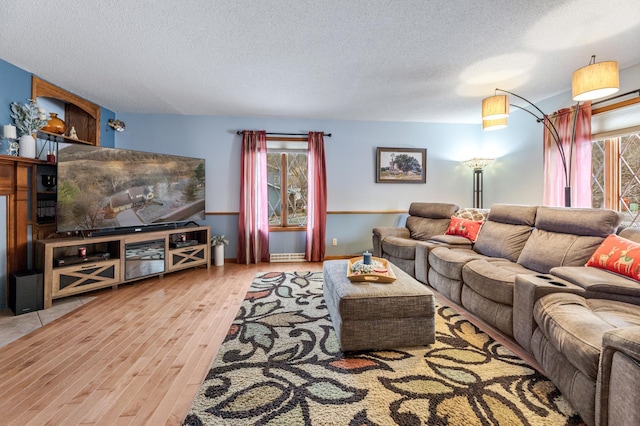 living room with a textured ceiling and light wood-type flooring