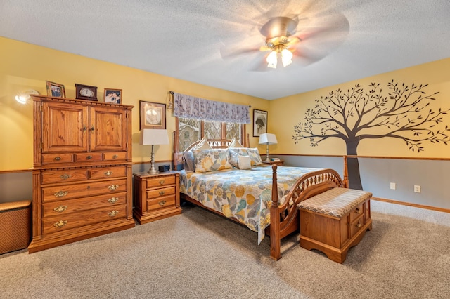 bedroom featuring a textured ceiling, light colored carpet, and ceiling fan