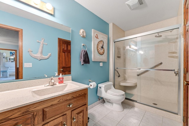 bathroom featuring tile patterned floors, vanity, toilet, and a shower with shower door