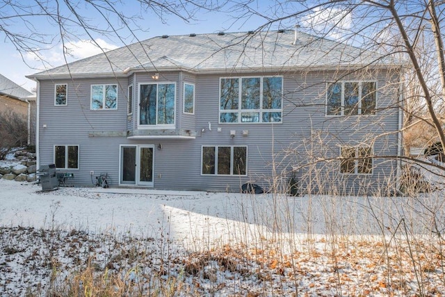 view of snow covered rear of property