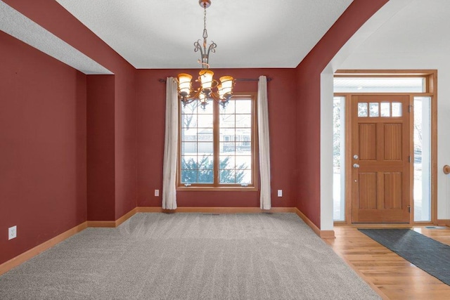 foyer with light hardwood / wood-style flooring and a notable chandelier