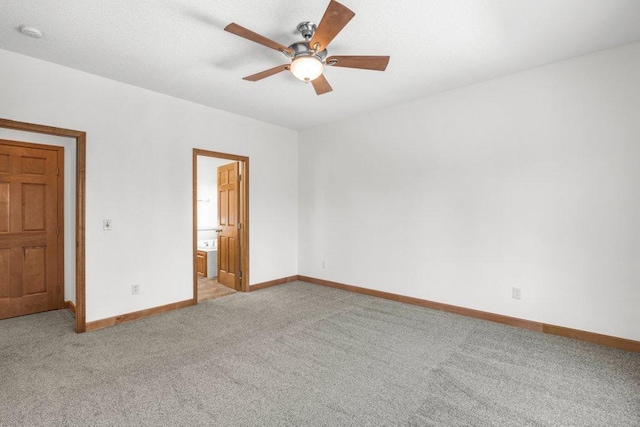 unfurnished bedroom with ensuite bathroom, ceiling fan, and light carpet