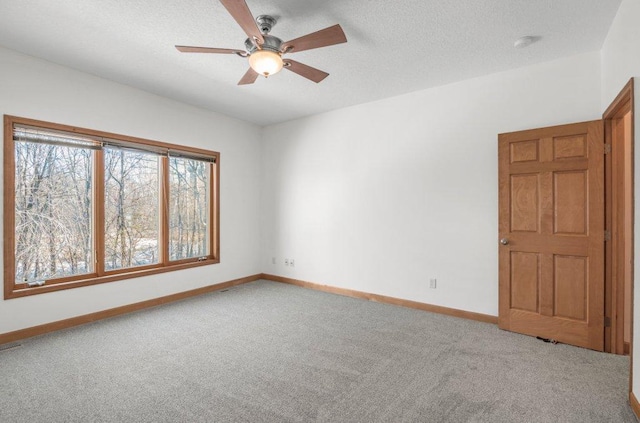 carpeted empty room featuring ceiling fan and a textured ceiling