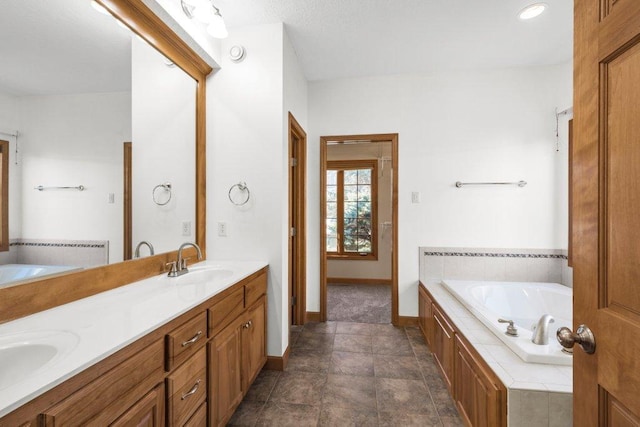 bathroom with tile patterned floors, tiled bath, and vanity