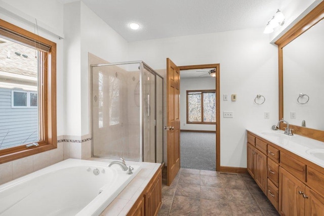 bathroom with separate shower and tub, ceiling fan, vanity, and a textured ceiling