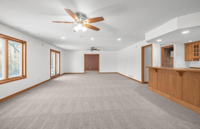 carpeted spare room featuring a textured ceiling and ceiling fan