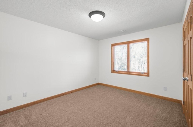 carpeted spare room with a textured ceiling