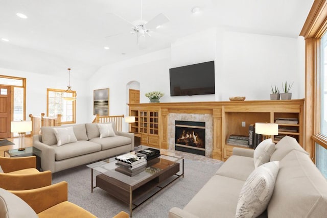 carpeted living room with ceiling fan and lofted ceiling