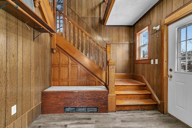 stairs with hardwood / wood-style flooring and wooden walls