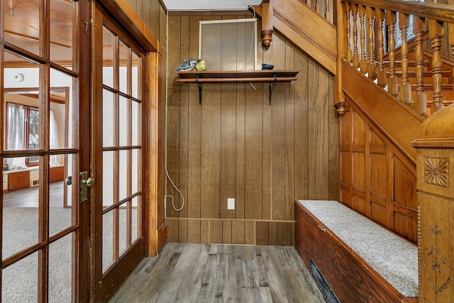 mudroom with hardwood / wood-style flooring, wood walls, and french doors