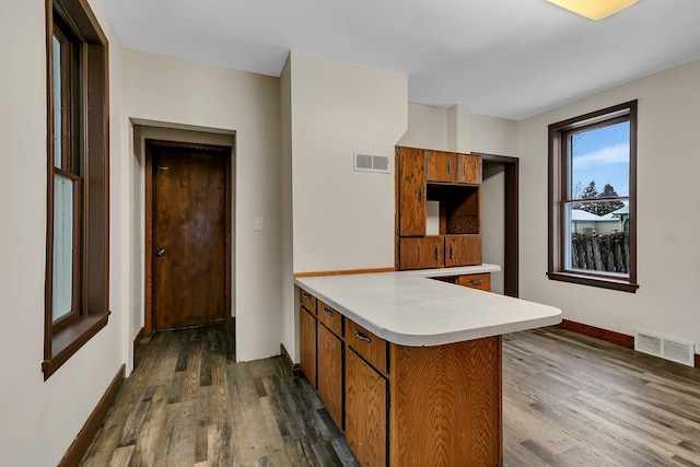 kitchen featuring kitchen peninsula and dark hardwood / wood-style flooring