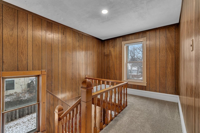 hall with carpet flooring and wood walls