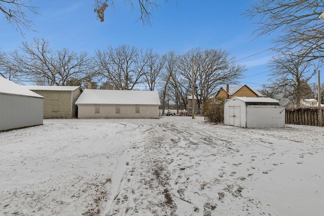 yard layered in snow featuring a storage shed