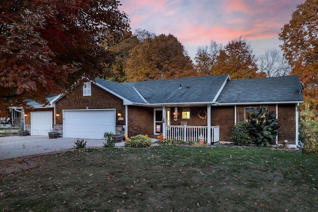 ranch-style home featuring an attached garage, driveway, a porch, and a front yard