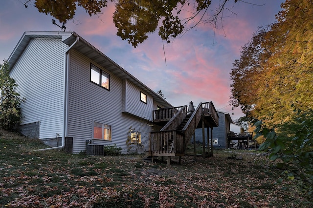 back of property with a deck and stairway