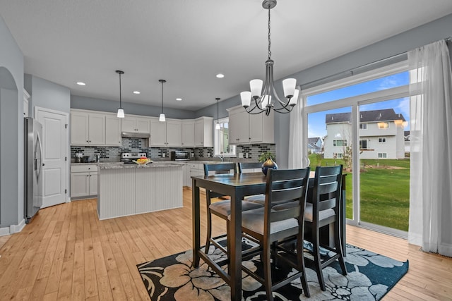 dining room featuring recessed lighting, an inviting chandelier, a toaster, and light wood-type flooring