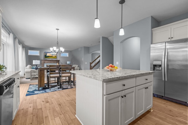 kitchen featuring open floor plan, dishwashing machine, stainless steel refrigerator with ice dispenser, white cabinets, and light wood-style flooring