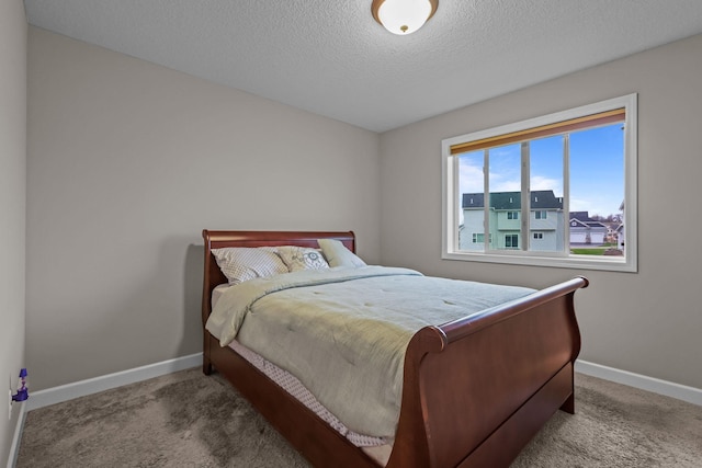 carpeted bedroom featuring baseboards and a textured ceiling