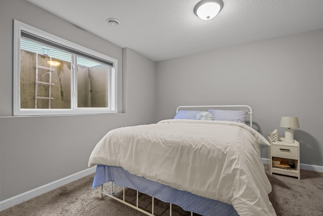 carpeted bedroom featuring baseboards and a textured ceiling