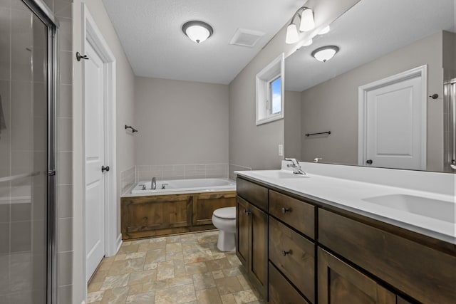 full bathroom featuring a garden tub, double vanity, stone finish floor, a shower stall, and a sink