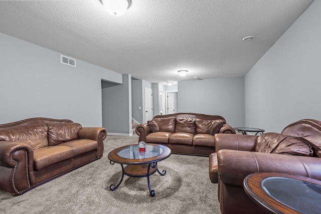 carpeted living area with visible vents and a textured ceiling