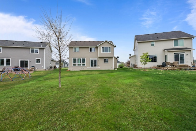 rear view of property featuring a lawn and a patio