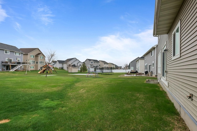 view of yard featuring a patio, playground community, and a residential view