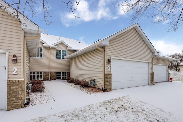 view of snow covered exterior with a garage