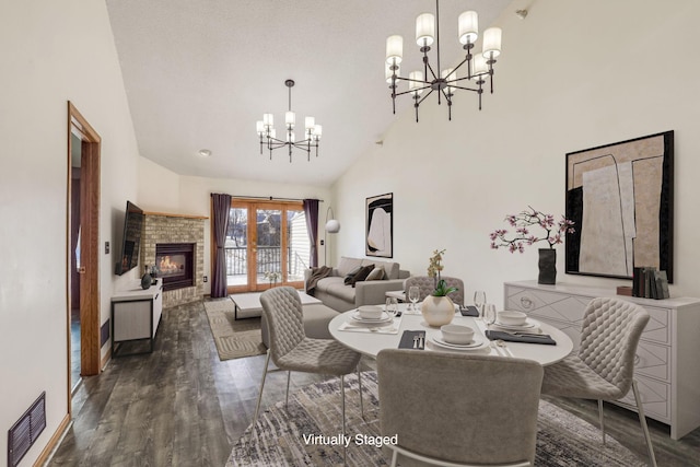 dining area featuring a chandelier, high vaulted ceiling, and dark hardwood / wood-style flooring