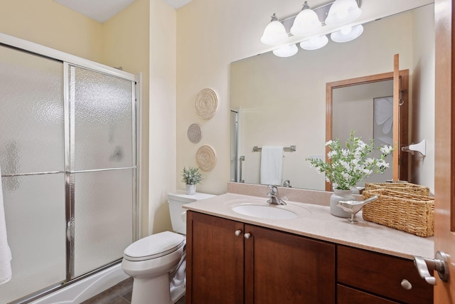 bathroom featuring toilet, a shower stall, and vanity