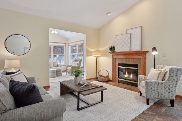 living room featuring lofted ceiling and a tiled fireplace