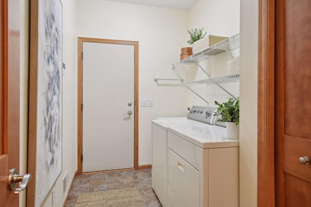 laundry area with laundry area, separate washer and dryer, and baseboards