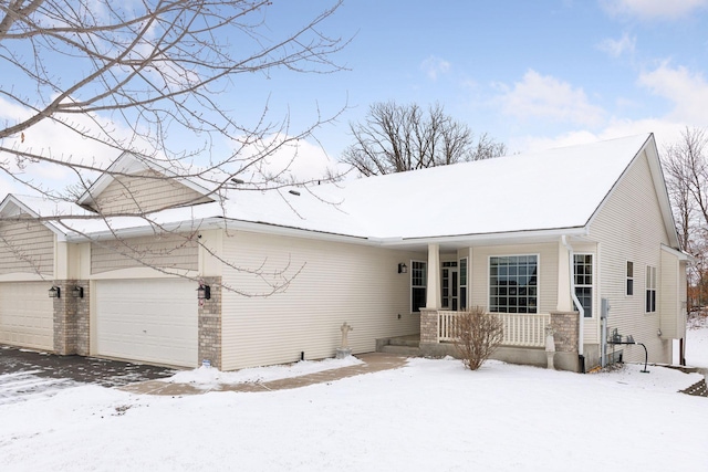 ranch-style house featuring covered porch and an attached garage