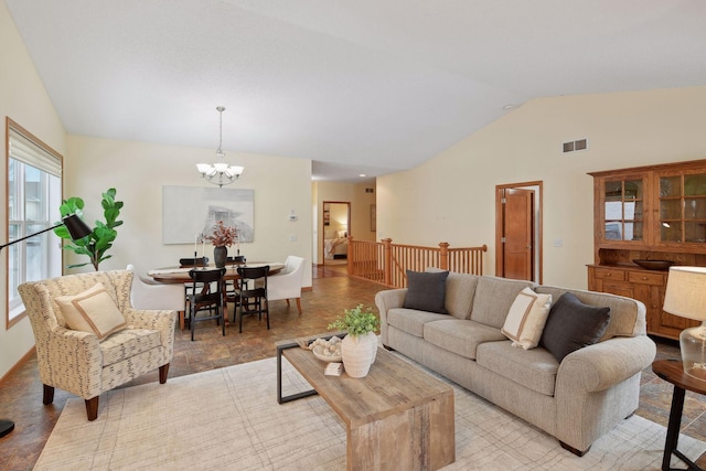 living room featuring vaulted ceiling, a chandelier, and visible vents