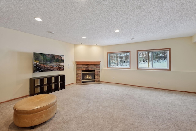 living room featuring a stone fireplace, baseboards, and a textured ceiling