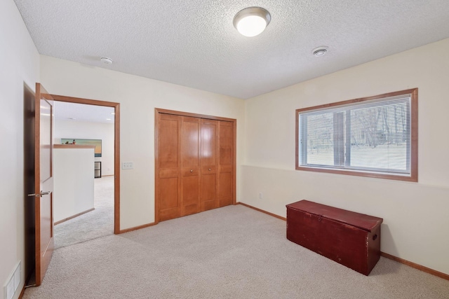 bedroom with a closet, visible vents, light carpet, and baseboards