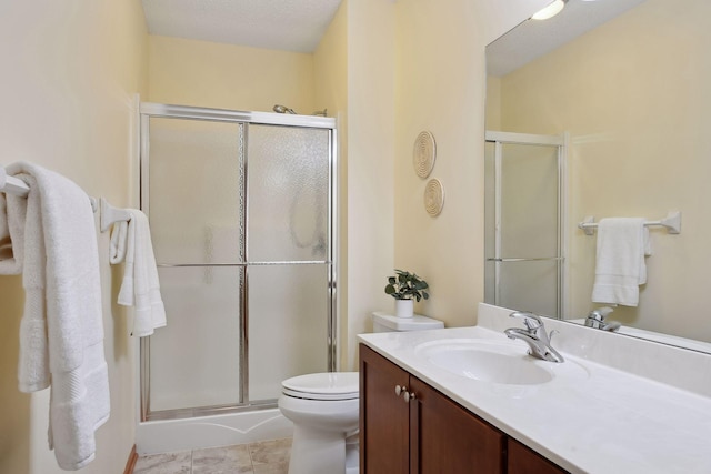 full bathroom featuring toilet, a stall shower, and vanity