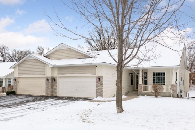 view of front of house featuring a garage, brick siding, and a porch