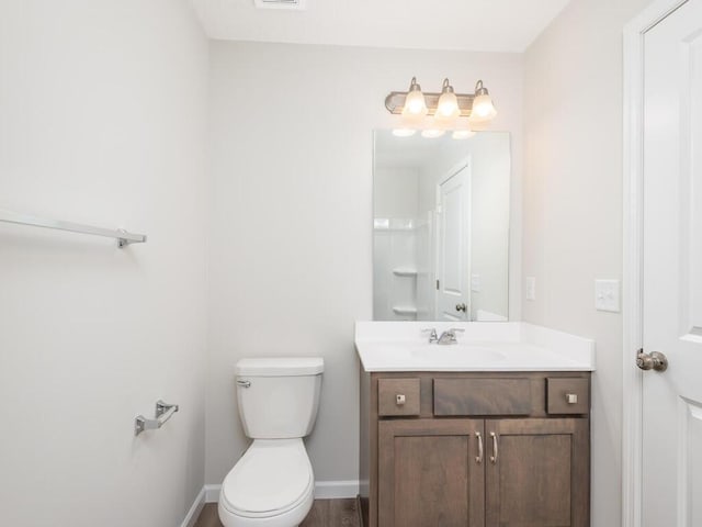 bathroom featuring vanity, wood-type flooring, and toilet