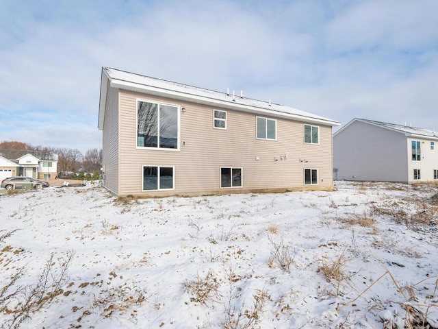 view of snow covered back of property