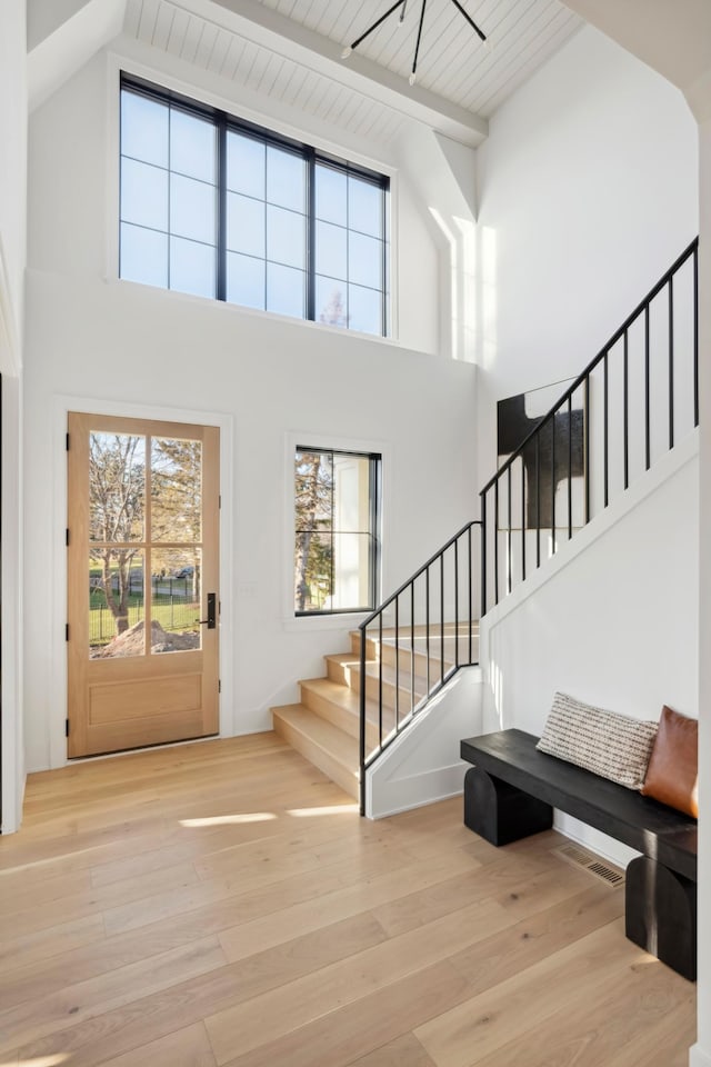 entryway with light hardwood / wood-style floors, wooden ceiling, beam ceiling, and high vaulted ceiling